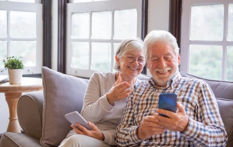 couple with phone discussing WellCheck service options  for seniors