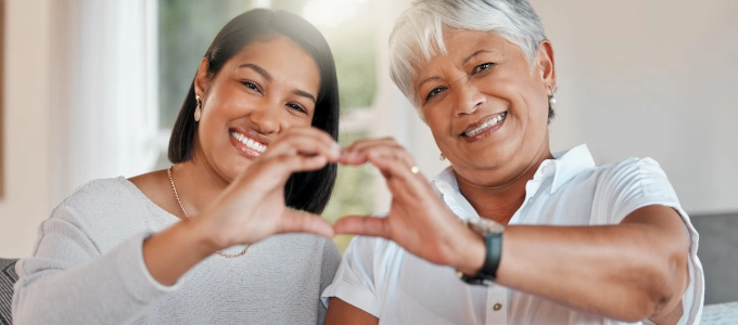 mother and daughter forming heart with hands
